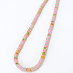 Necklace with multicolored pink, light blue and green beads on a white background