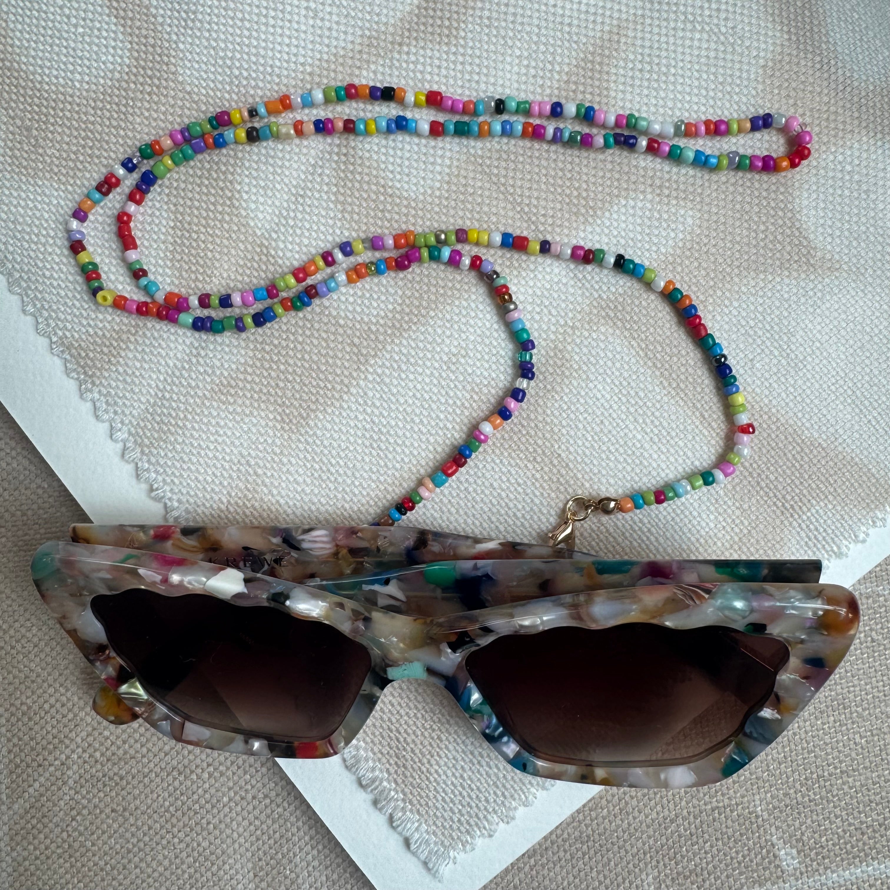 Picture of a multicolored beaded lanyard used as a sunglasses holder.