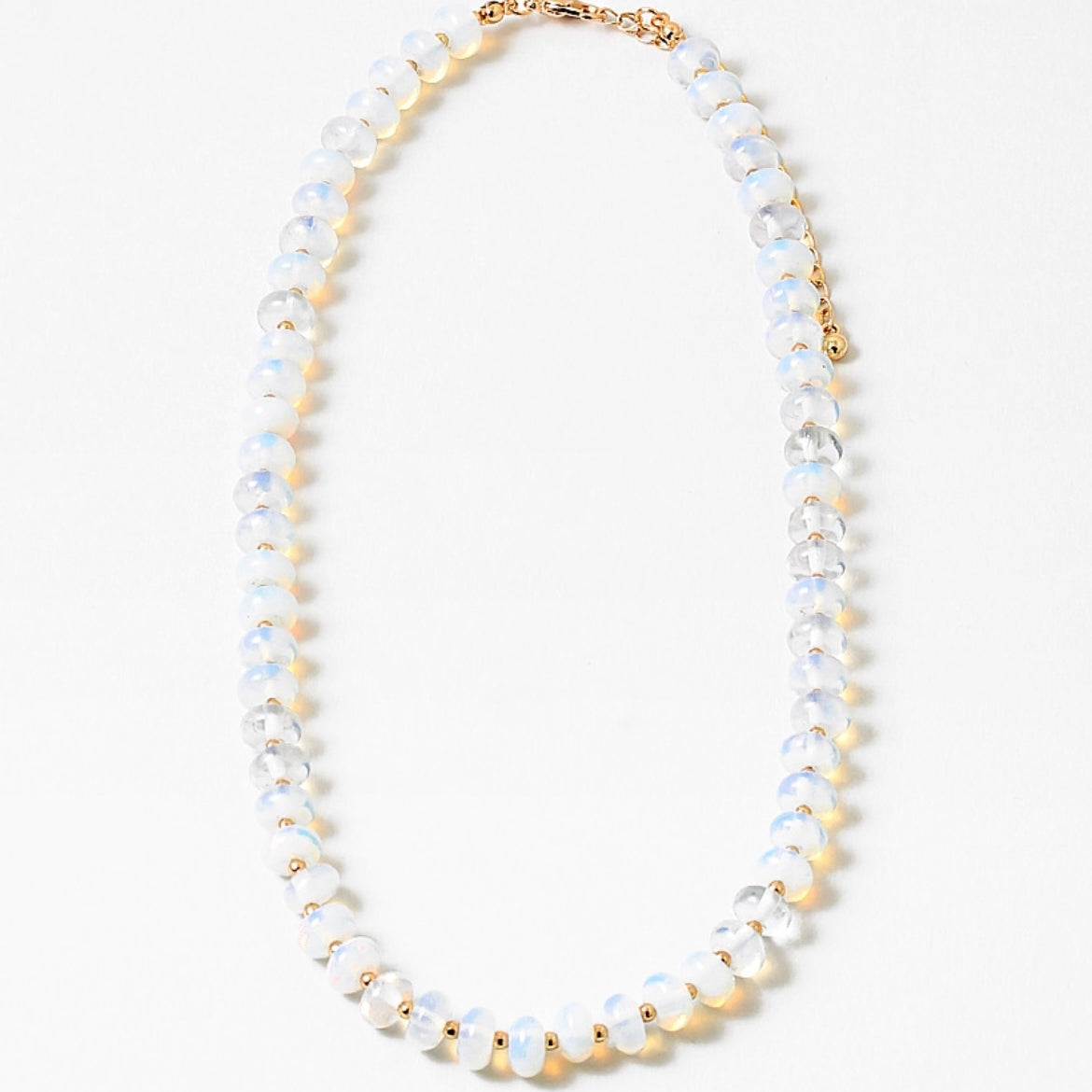 Necklace with opaque white and gold beads on a white background