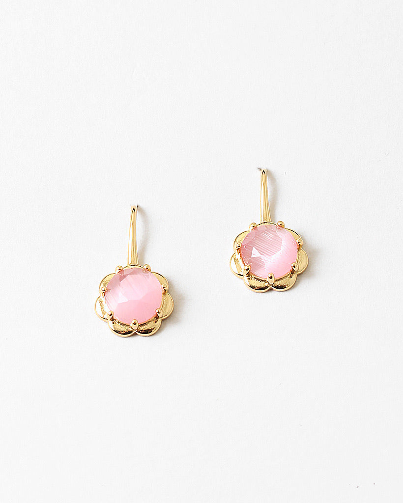 Gold flower earrings with pink gemstones on a white background