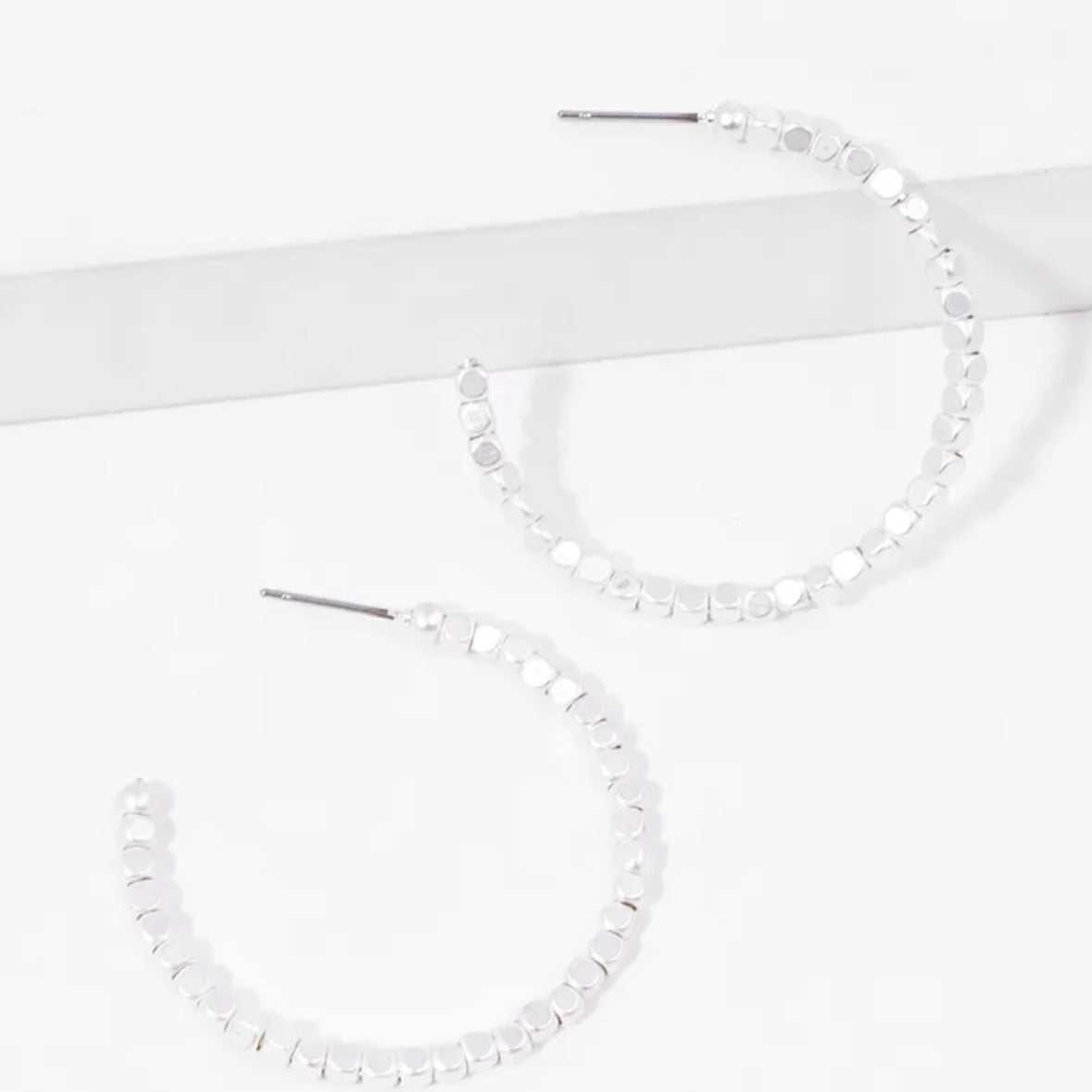 Picture of a set of white bead hoop earrings.