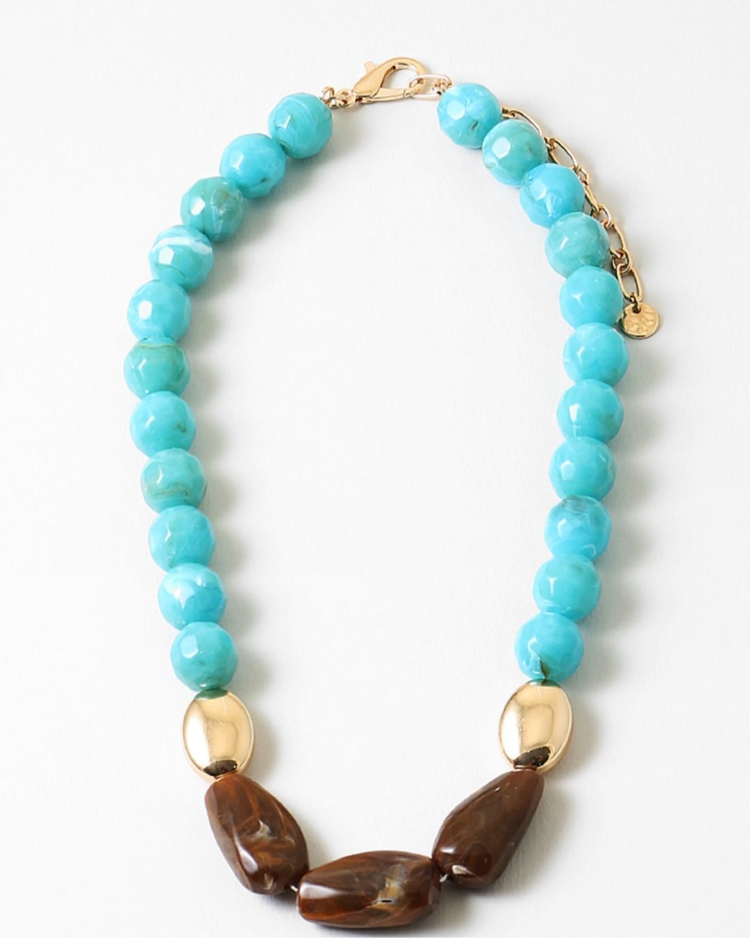 Chunky turquoise beaded necklace with gold and brown bead accents on a white background