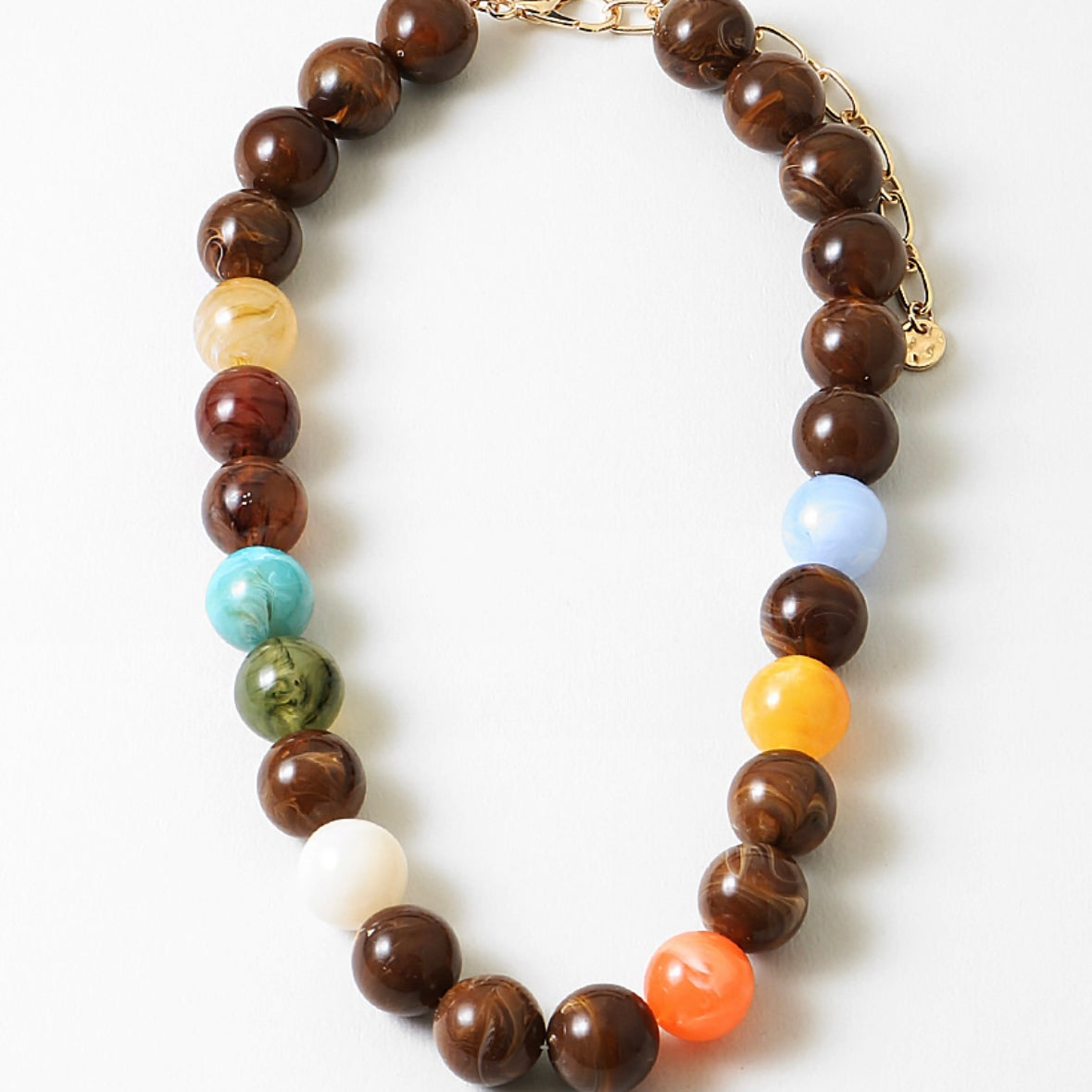 Jewelry necklace with large multicolored beads on a white background