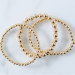Picture of set of three gold bead bracelets in varying bead sizes.