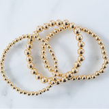 Picture of set of three gold bead bracelets in varying bead sizes.