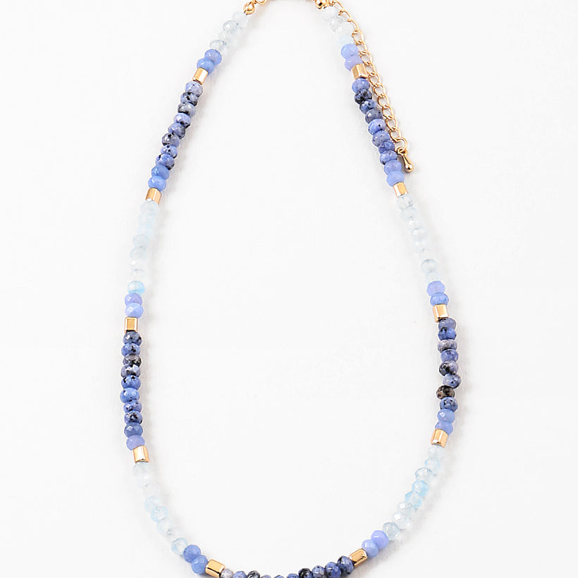 Necklace with blue, white and gold beads on a white background