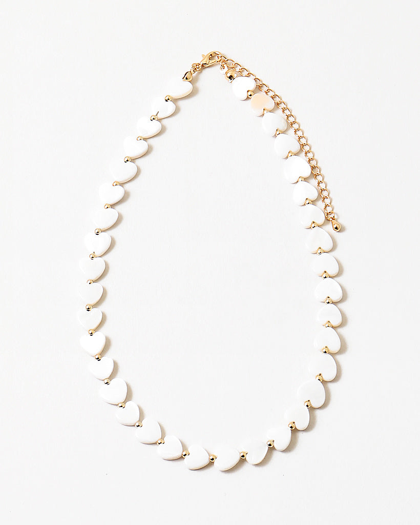 Necklace with white heart shaped beads on a white background