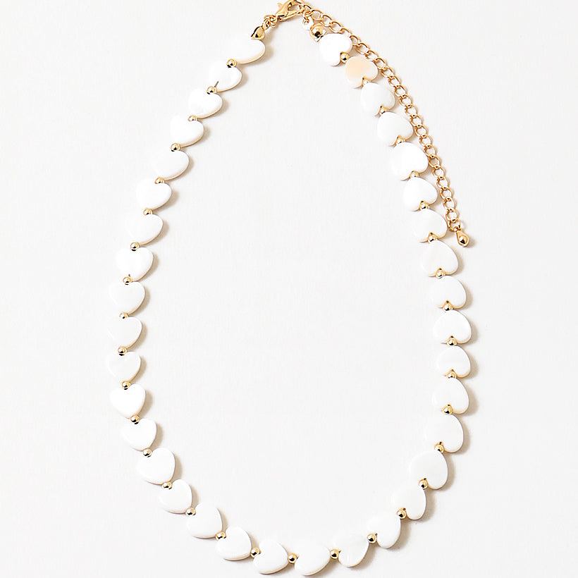Necklace with white heart shaped beads on a white background