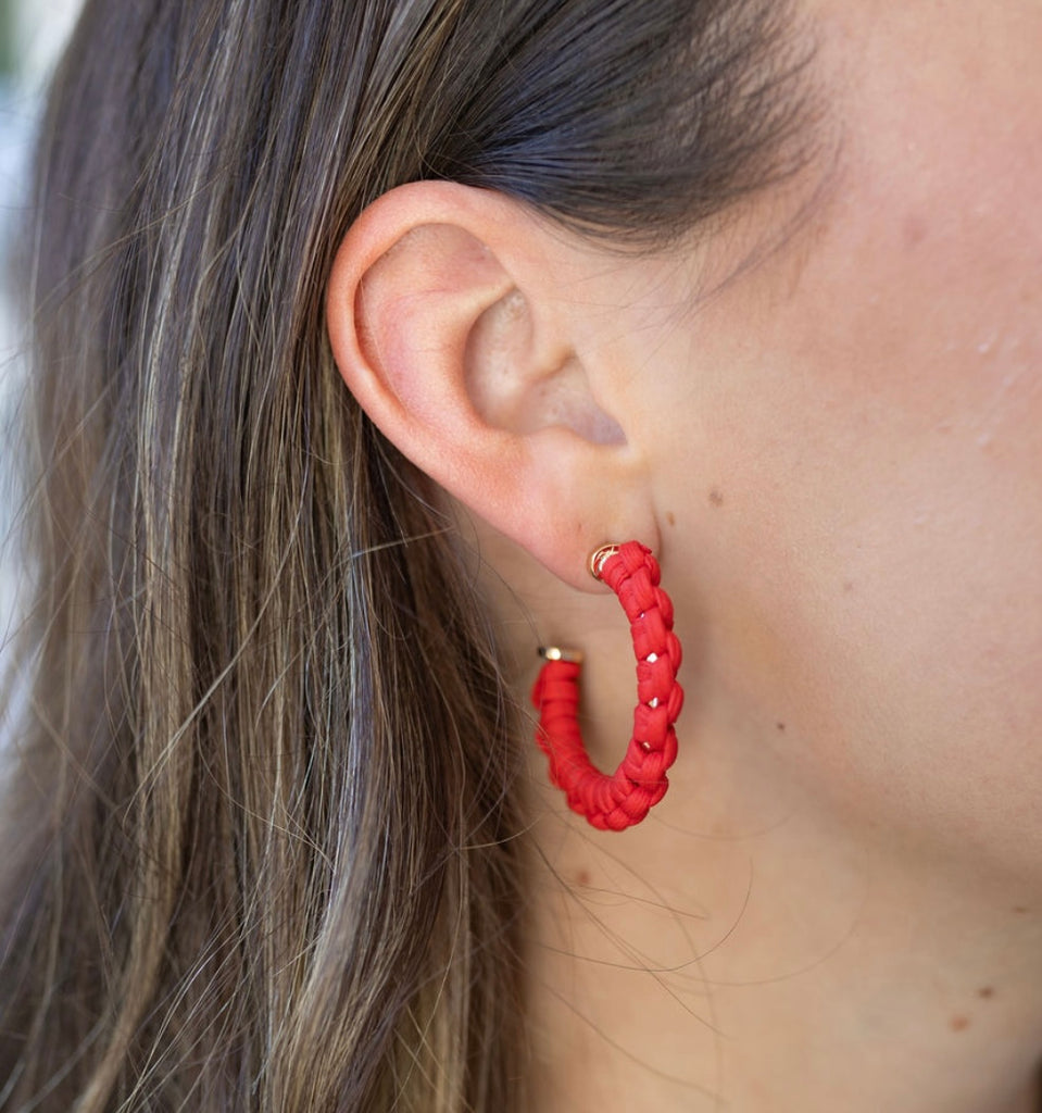 Picture of model wearing a hoop earring that is wrapped in red cord.