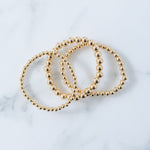 Picture of set of three gold beaded bracelets in varying bead sizes.