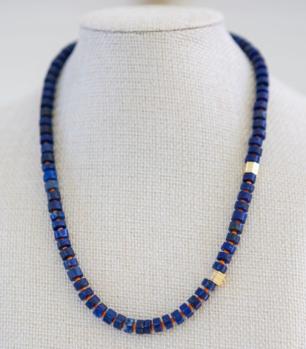 Necklace with blue beads on a mannequin against a white background