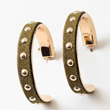 Pair of green suede hoop earrings with rose gold accents and studded details on a white background