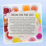 Jewelry sets with colorful orange and pink beads in small containers on a blue gradient background.