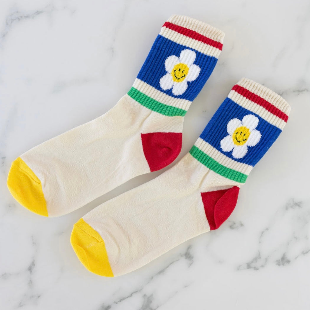 Colorful socks with retro flower primary color block design on a marble background