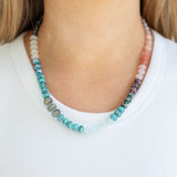 Necklace with multicolored beads worn by a person on a white background