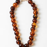 Brown beaded necklace on a white background