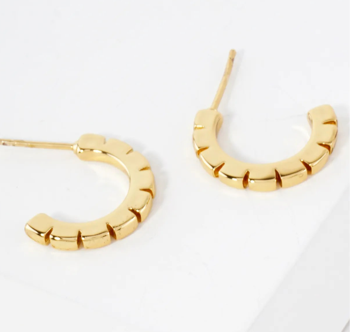 Gold hoop earrings on a white background