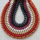 Multicolored beaded necklaces on a textured white background