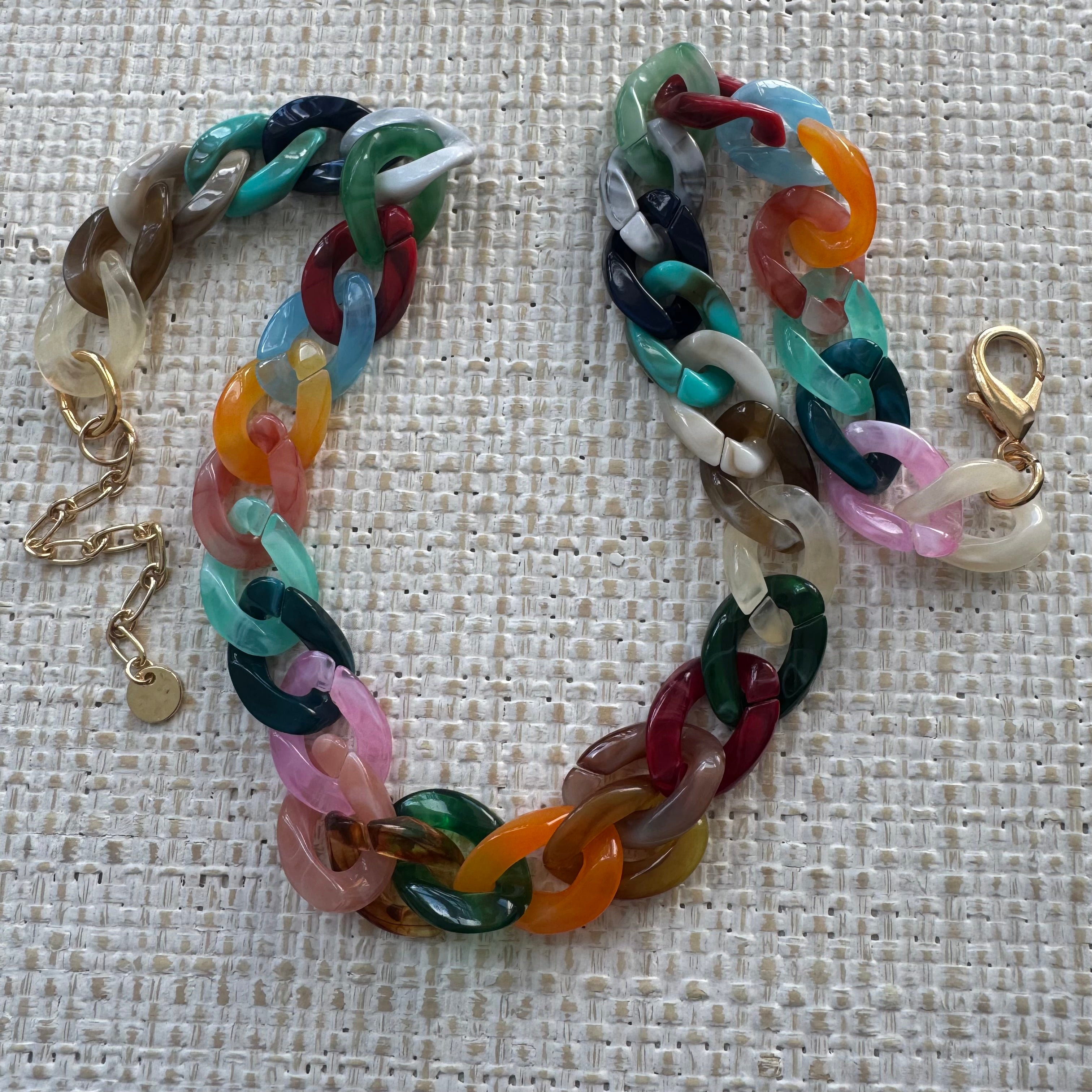 Colorful chain bracelet on a textured beige background