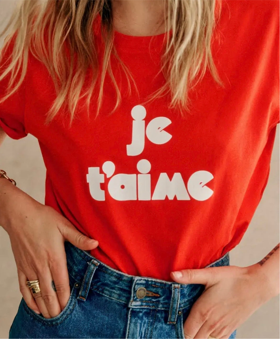 Red t-shirt with 'je t'aime' text worn by a person, with a neutral background