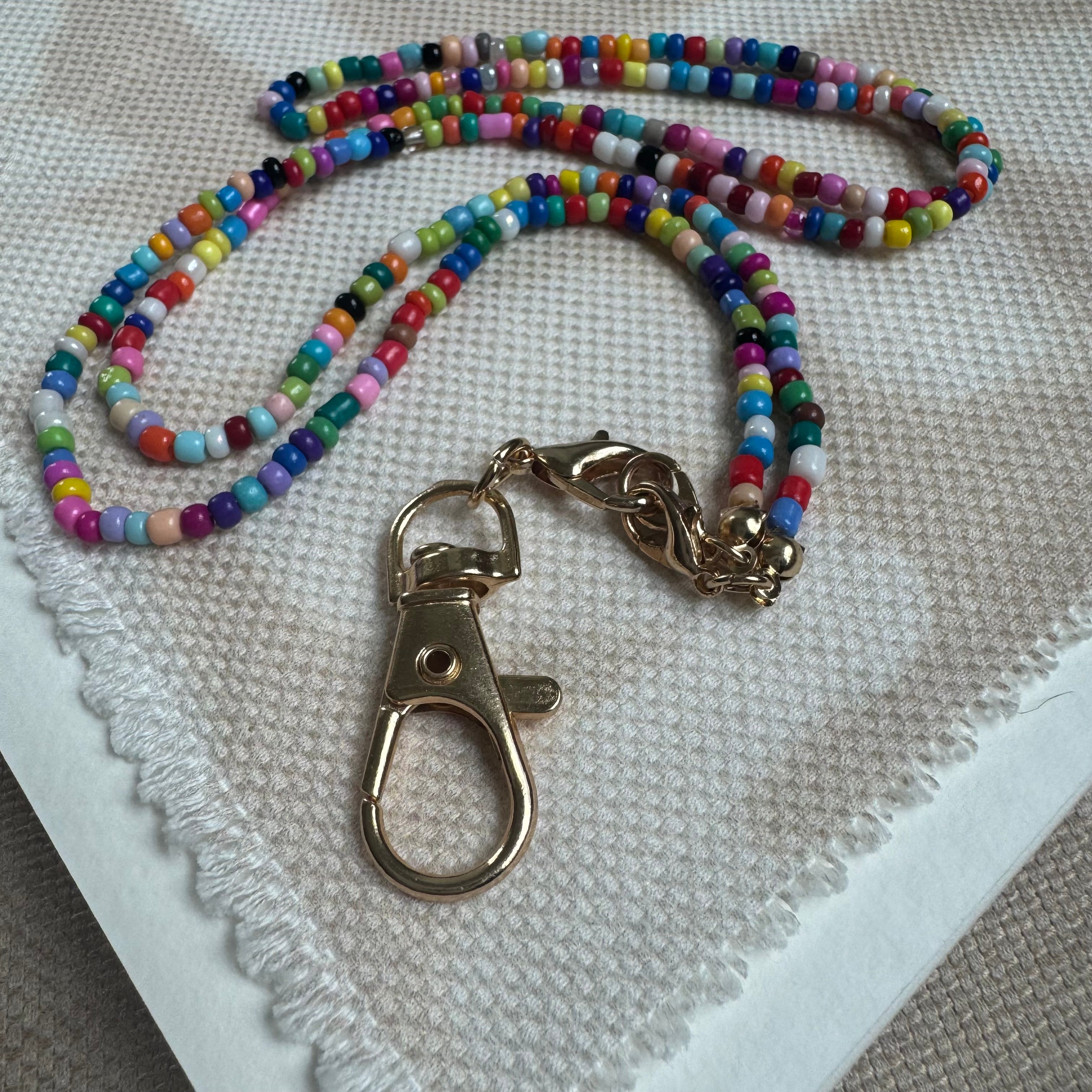 Picture of a multicolored beaded lanyard with a large gold clasp.