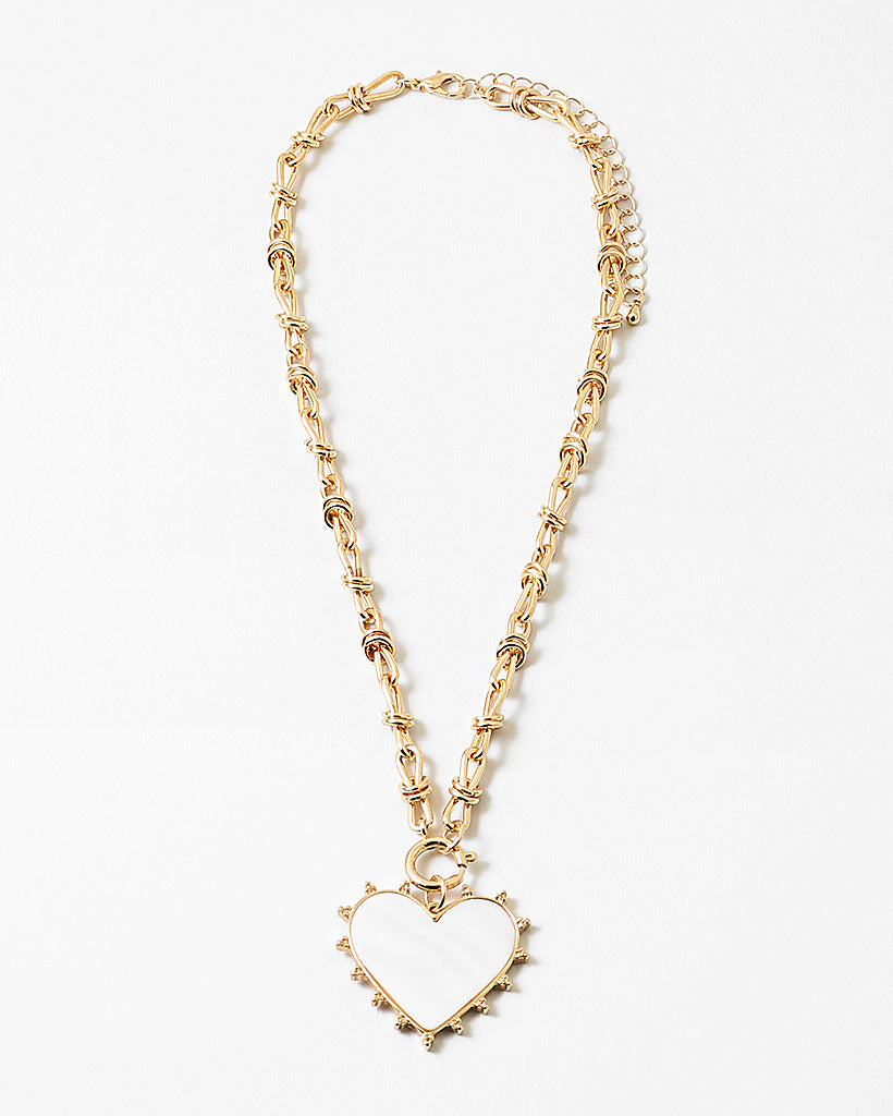 Picture of gold toggle chain with a large white heart pendant with a gold border.