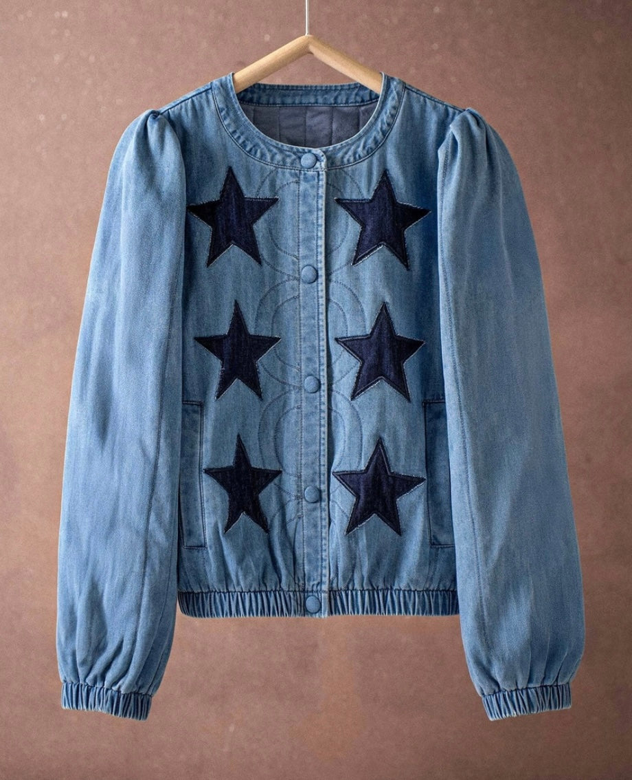 Blue denim jacket with black star patterns on a brown background