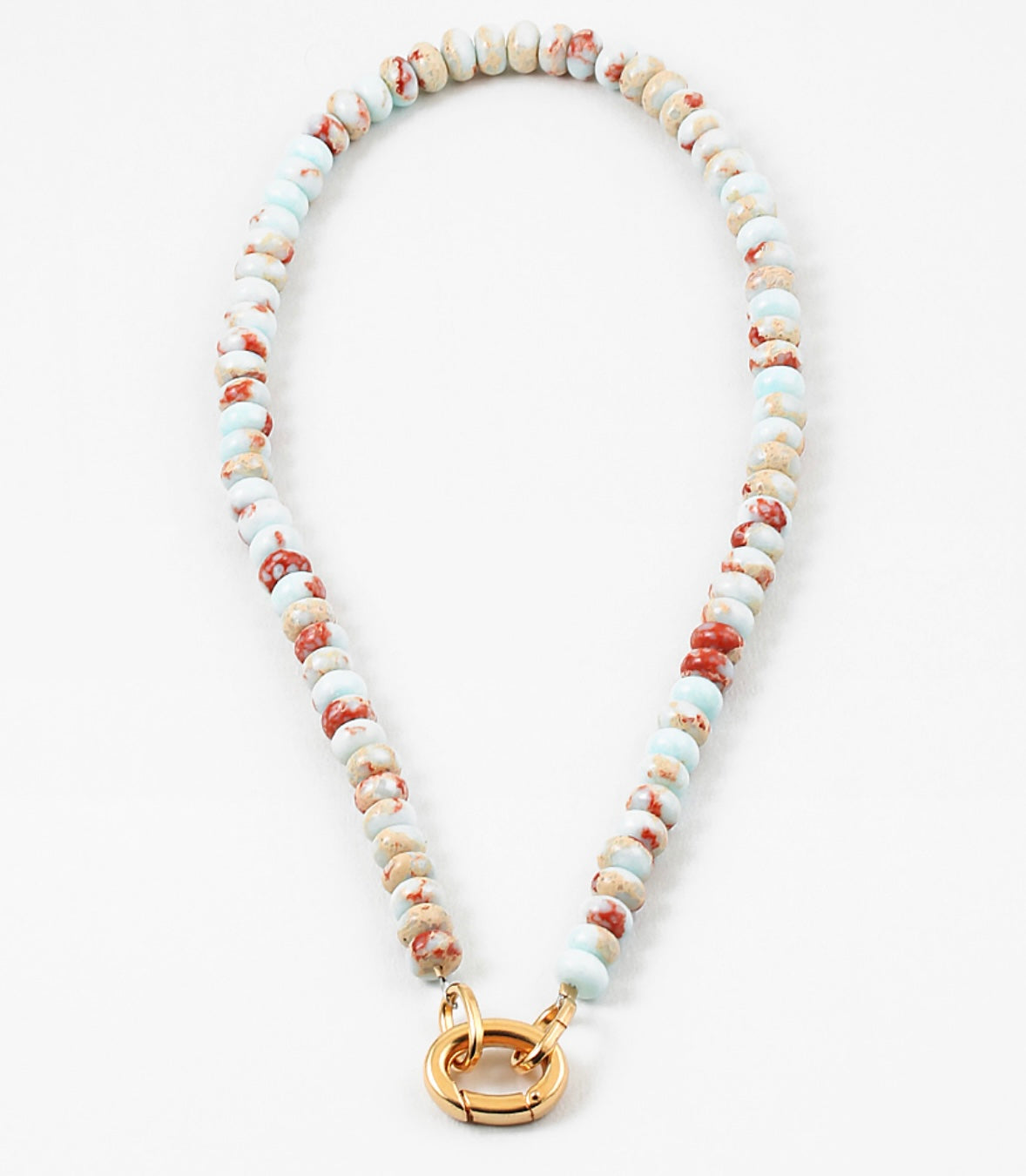White bead necklace with rust colored flecks and a large gold carabiner clasp.