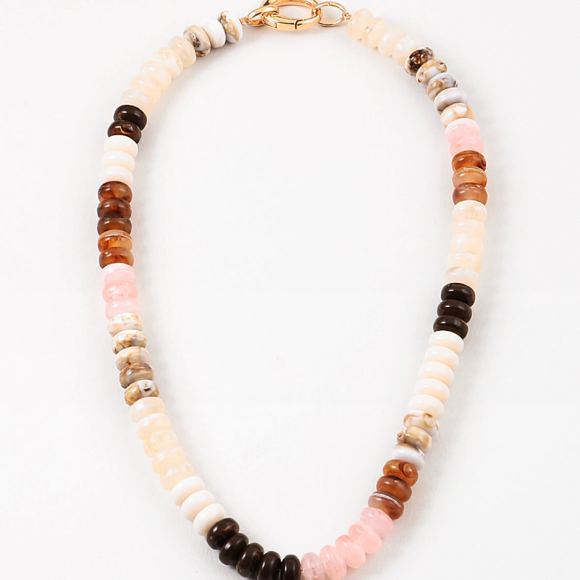 Necklace with multicolored cream and brown beads on a white background