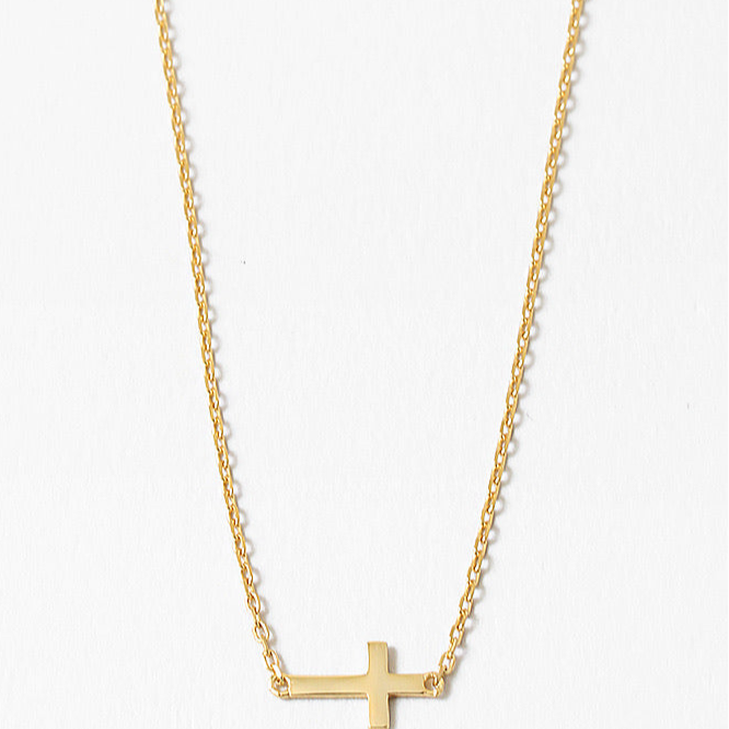 Gold cross necklace on a white background
