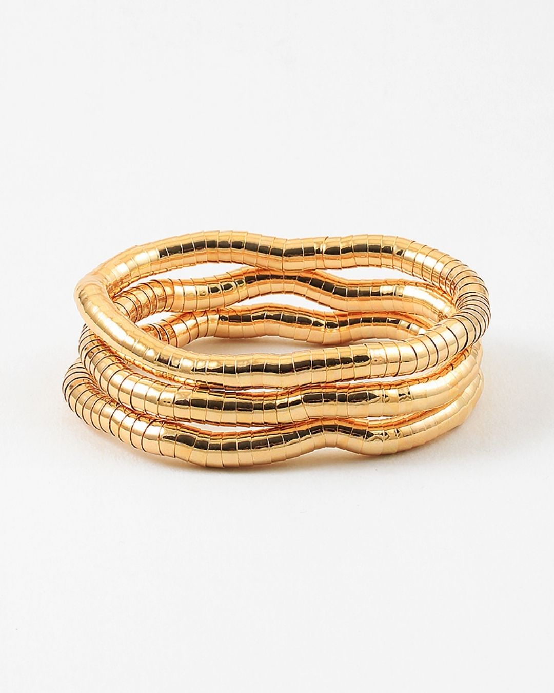 Set of three gold stretch bracelets on a white background