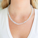 Opalite bead necklace being worn by a person with a blurred background