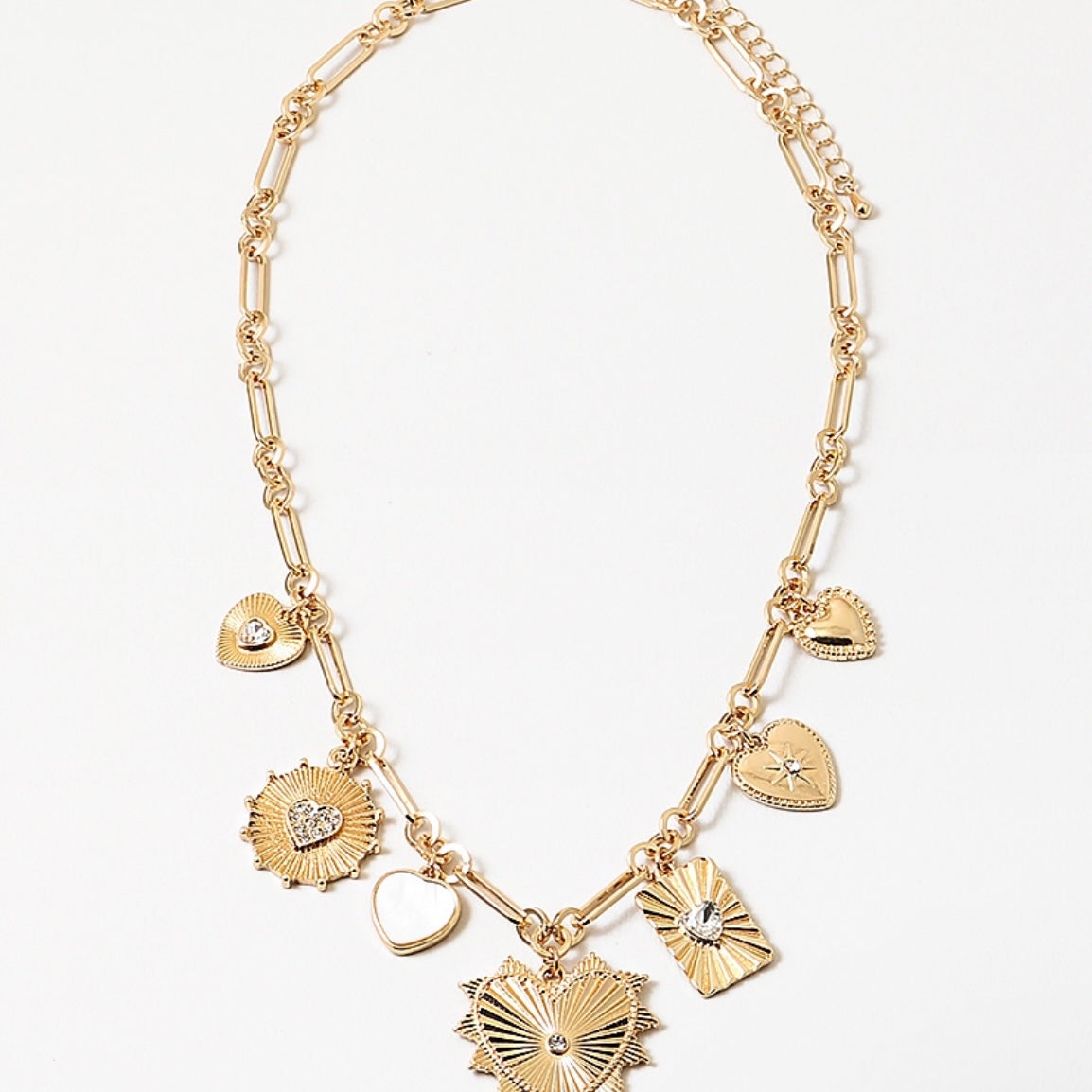 Gold chain necklace with seven gold lucky charms link attached and a gold heart medallion