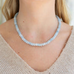 Necklace with light blue beads worn by a person