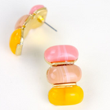 Colorful yellow and pink layered earring on a white background