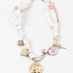 Decorative scarf necklace with floral and heart charms on a white background