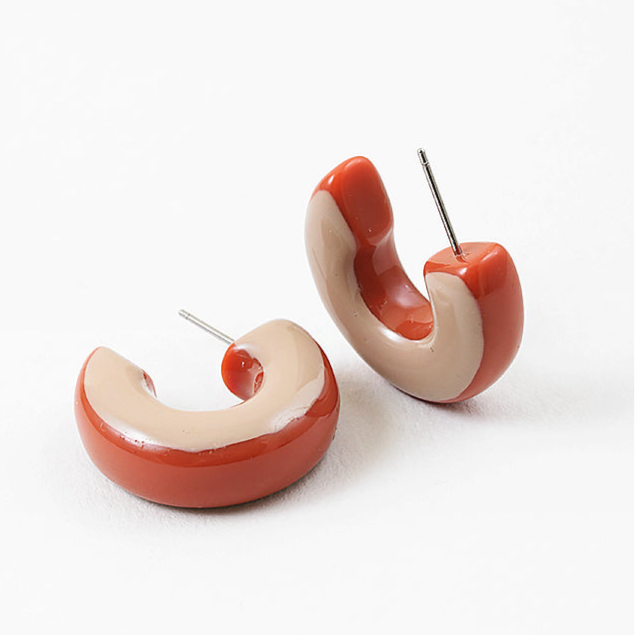 Pair of red and beige hoop earrings on a white background