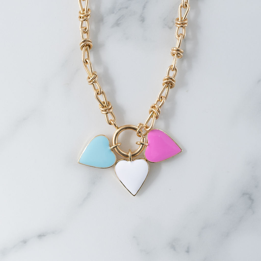Picture of gold toggle chain with blue, white and pink heart pendants.