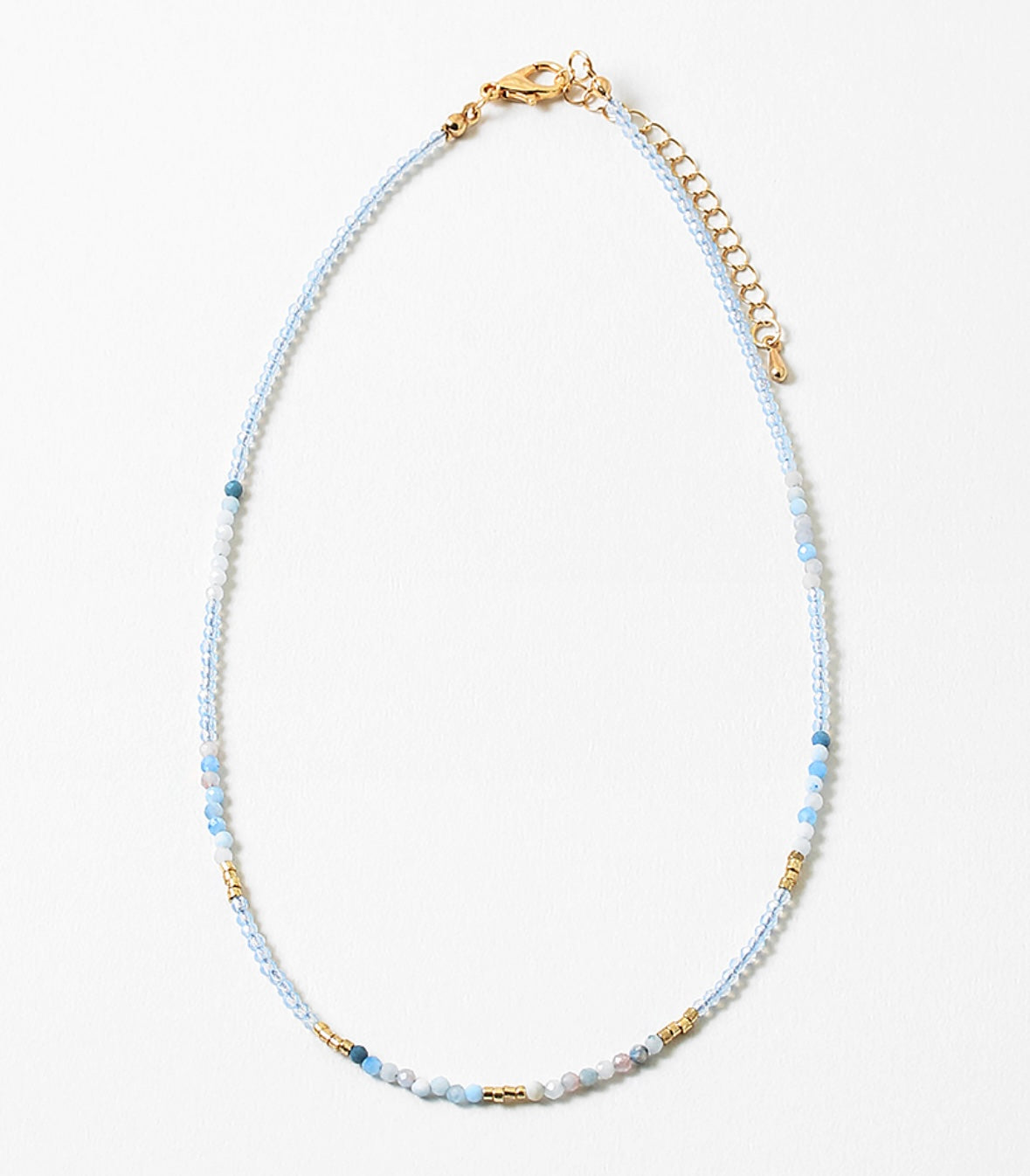 Dainty bead necklace with clear blue beads, gold and some solid blue beads.