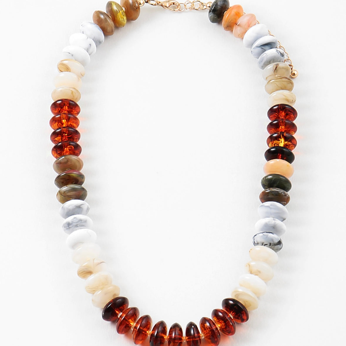 Necklace with cream, amber, gray and brown beads on a white background