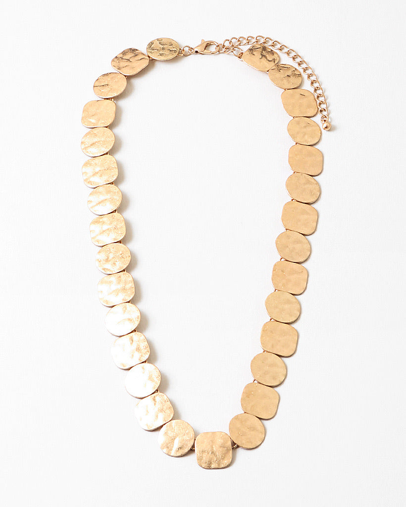 Gold necklace made with round pendants on a white background