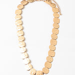 Gold necklace made with round pendants on a white background