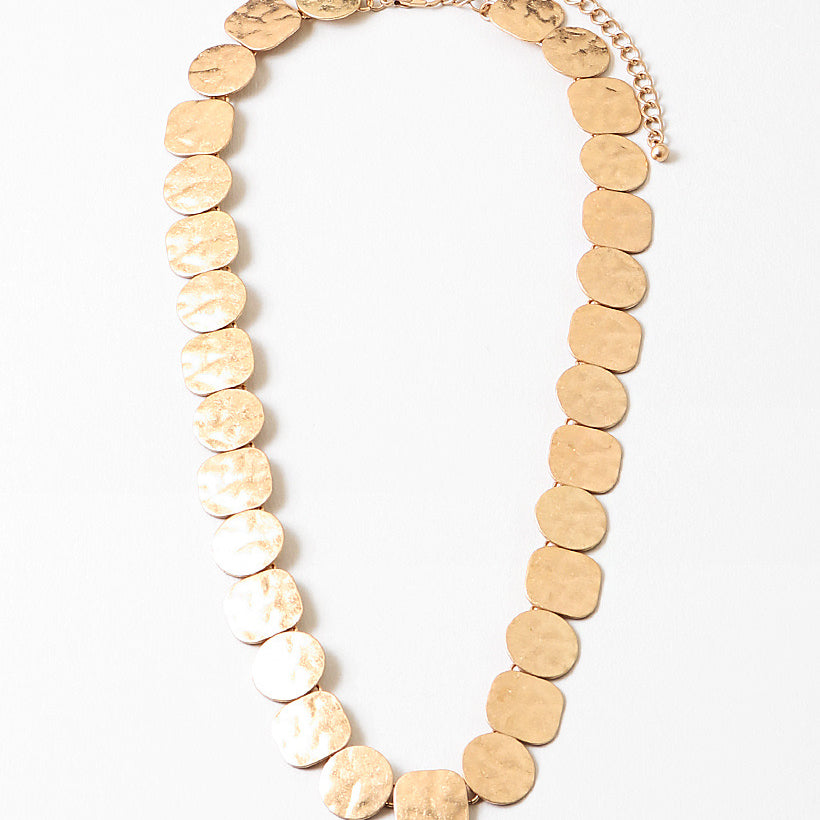Gold necklace made with round pendants on a white background