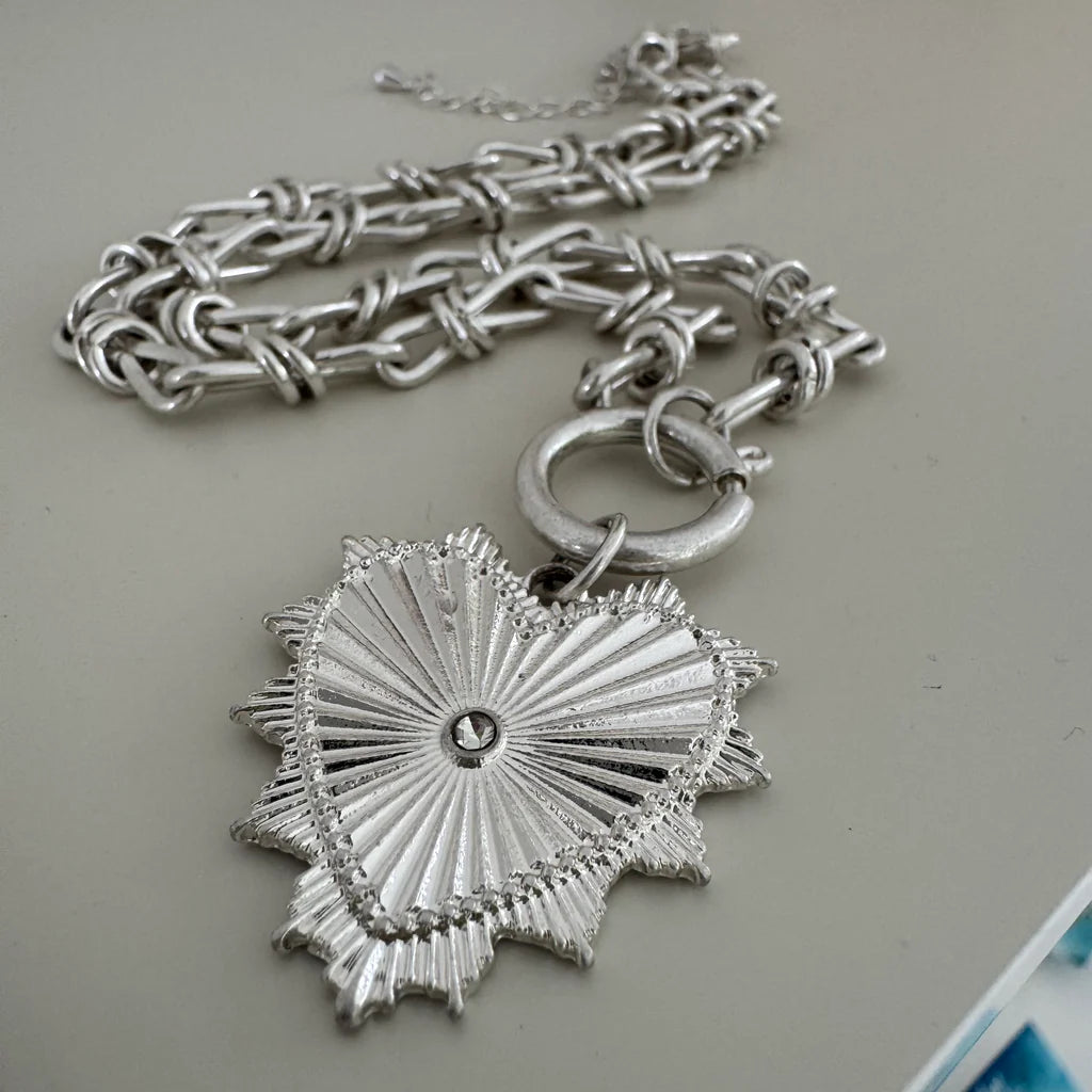 Picture of a bold silver toggle chain necklace with a large textured heart pendant.