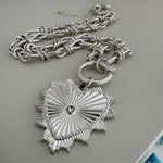 Picture of a bold silver toggle chain necklace with a large textured heart pendant.
