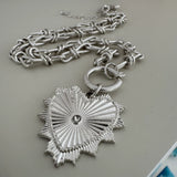 Picture of a bold silver toggle chain necklace with a large textured heart pendant.
