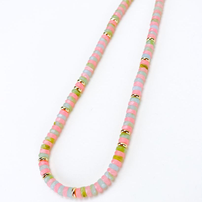 Necklace with multicolored pink, light blue and green beads on a white background