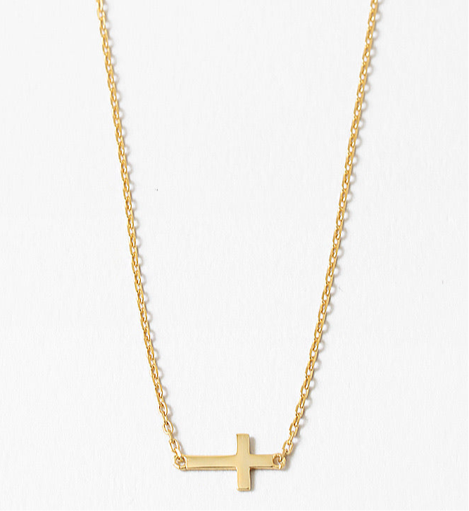Gold cross necklace on a white background