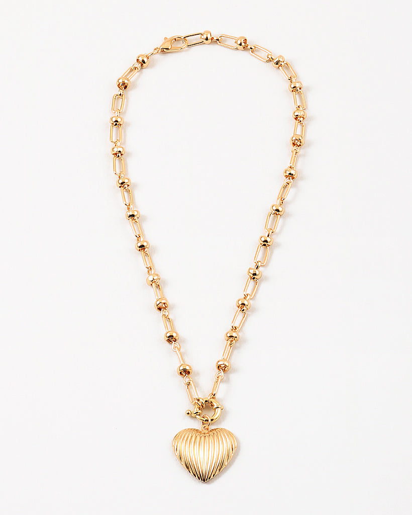 Gold necklace with a heart-shaped pendant on a white background