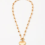 Gold necklace with a heart-shaped pendant on a white background